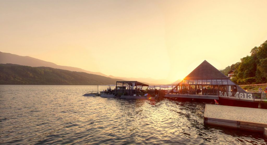 Das Bild zeigt die BAr Kap 4613 über dem Wasser des Millstätter See bei Abendstimmung und untergehender Sonne