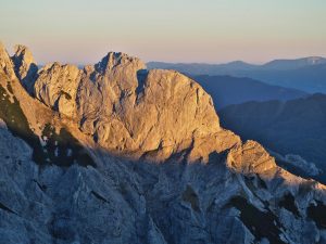 Das Bild zeigt eine große, sonnenbeschienende Felswand im Hochschwab Gebirge.
