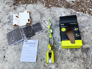 Das Bild zeigt ein Edelrid Ohm mit allen BStandteilen und der VErpackung auf einem Felsblock.
